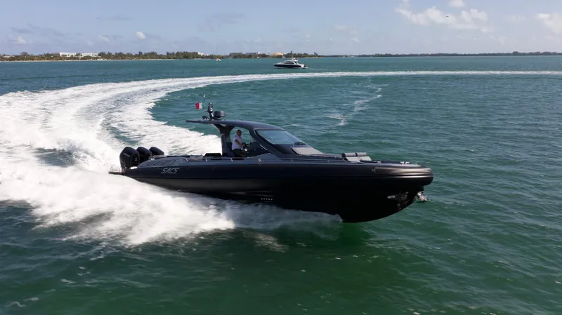  Yacht Photos Pics 2022 SACS 47 Rebel cruising on open water, creating a dynamic wake.