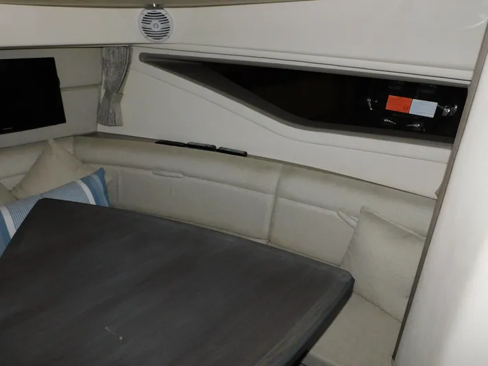 Not Guilty Yacht Photos Pics Interior seating area of a 2018 Sea Ray Sundancer yacht with a table and cushions.