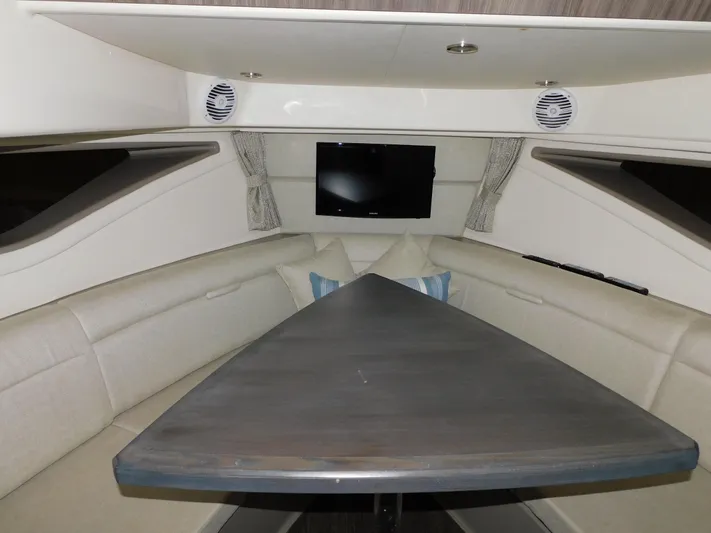 Not Guilty Yacht Photos Pics 2018 Sea Ray Sundancer cabin interior with triangular table and TV.