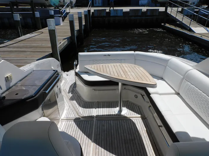 Not Guilty Yacht Photos Pics 2018 Sea Ray Sundancer boat interior with white seating and wooden table at dock.