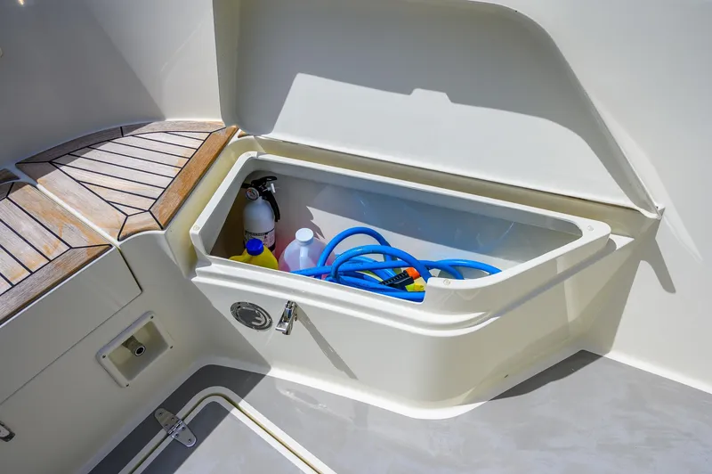  Yacht Photos Pics Storage compartment on 2019 Targa 27.2 boat with cleaning supplies and hose.