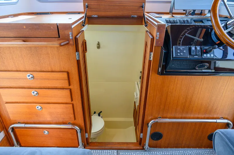  Yacht Photos Pics 2019 Targa 27.2 boat interior with wooden cabinetry and compact bathroom.