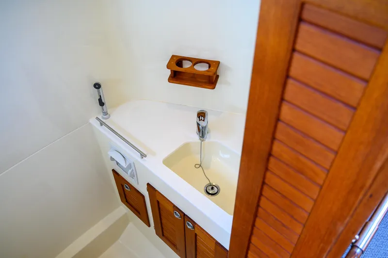  Yacht Photos Pics Compact bathroom in 2019 Targa 27.2 boat with wooden cabinets and sink.
