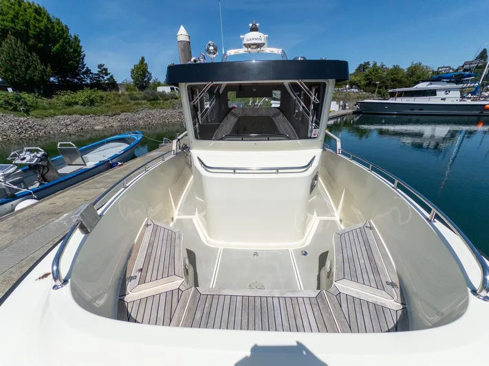  Yacht Photos Pics 2019 Targa 27.2 boat with spacious deck, docked in a serene marina setting.