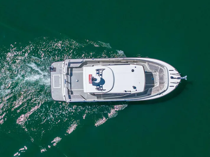  Yacht Photos Pics Aerial view of 2019 Targa 27.2 boat cruising on clear green water.