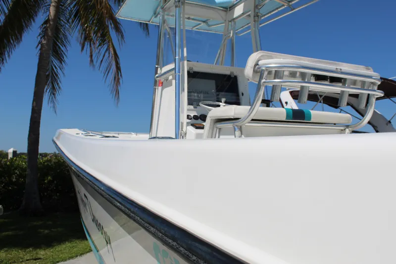  Yacht Photos Pics 2002 Contender 31 CC boat with sleek design, palm tree background, and clear blue sky.