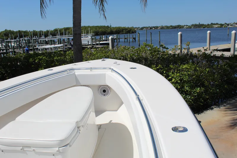  Yacht Photos Pics 2002 Contender 31 CC boat docked by a scenic waterfront with lush greenery.