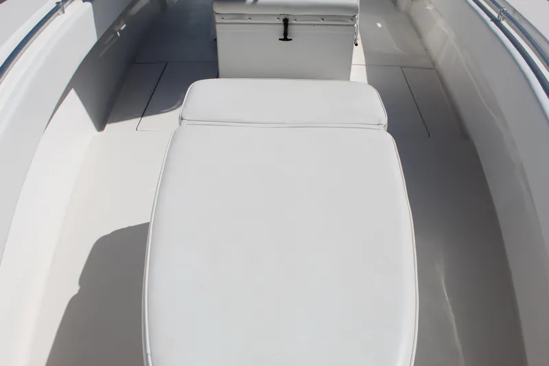  Yacht Photos Pics 2002 Contender 31 CC boat interior with white cushioned seating and storage.