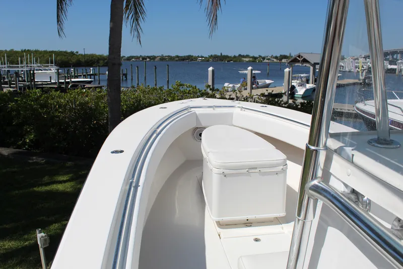  Yacht Photos Pics 2002 Contender 31 CC boat docked by a scenic waterfront with clear skies.