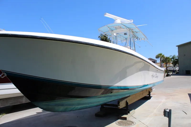  Yacht Photos Pics 2002 Contender 31 CC boat on dry dock, white hull, clear blue sky background.