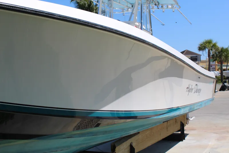  Yacht Photos Pics 2002 Contender 31 CC boat on display, sleek white hull, outdoor setting.