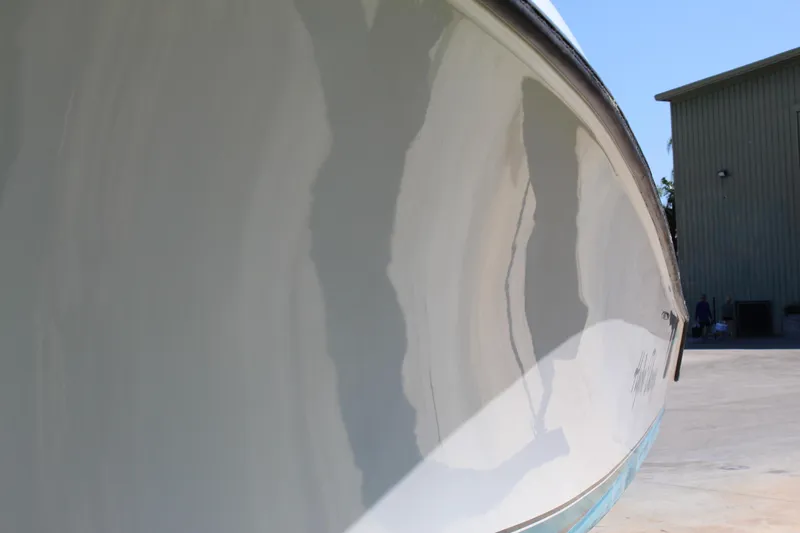  Yacht Photos Pics 2002 Contender 31 CC boat hull reflecting sunlight, parked near a building.