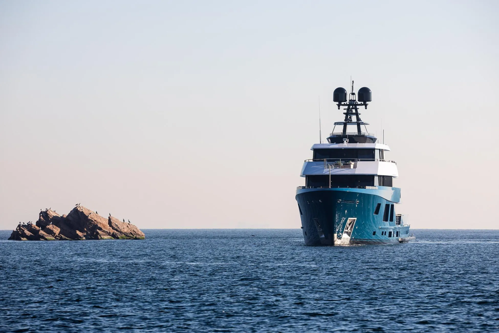 2024 Dunya Yachts Explorer cruising near rocky outcrop in open sea.