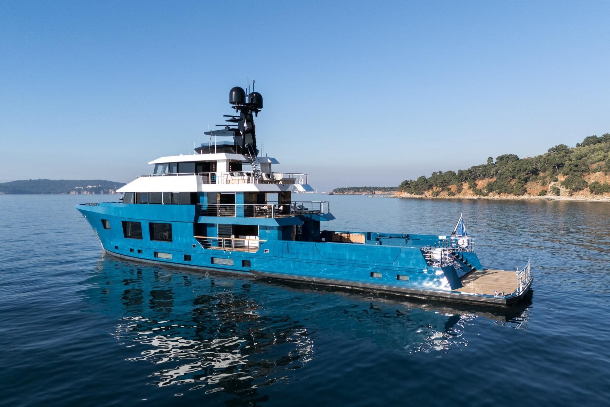 2024 Dunya Yachts Explorer cruising on calm waters near a scenic coastline.