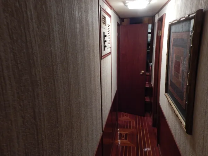 Top Coat Yacht Photos Pics 1974 Pacemaker Cockpit Motoryacht interior hallway with wood paneling and framed artwork.