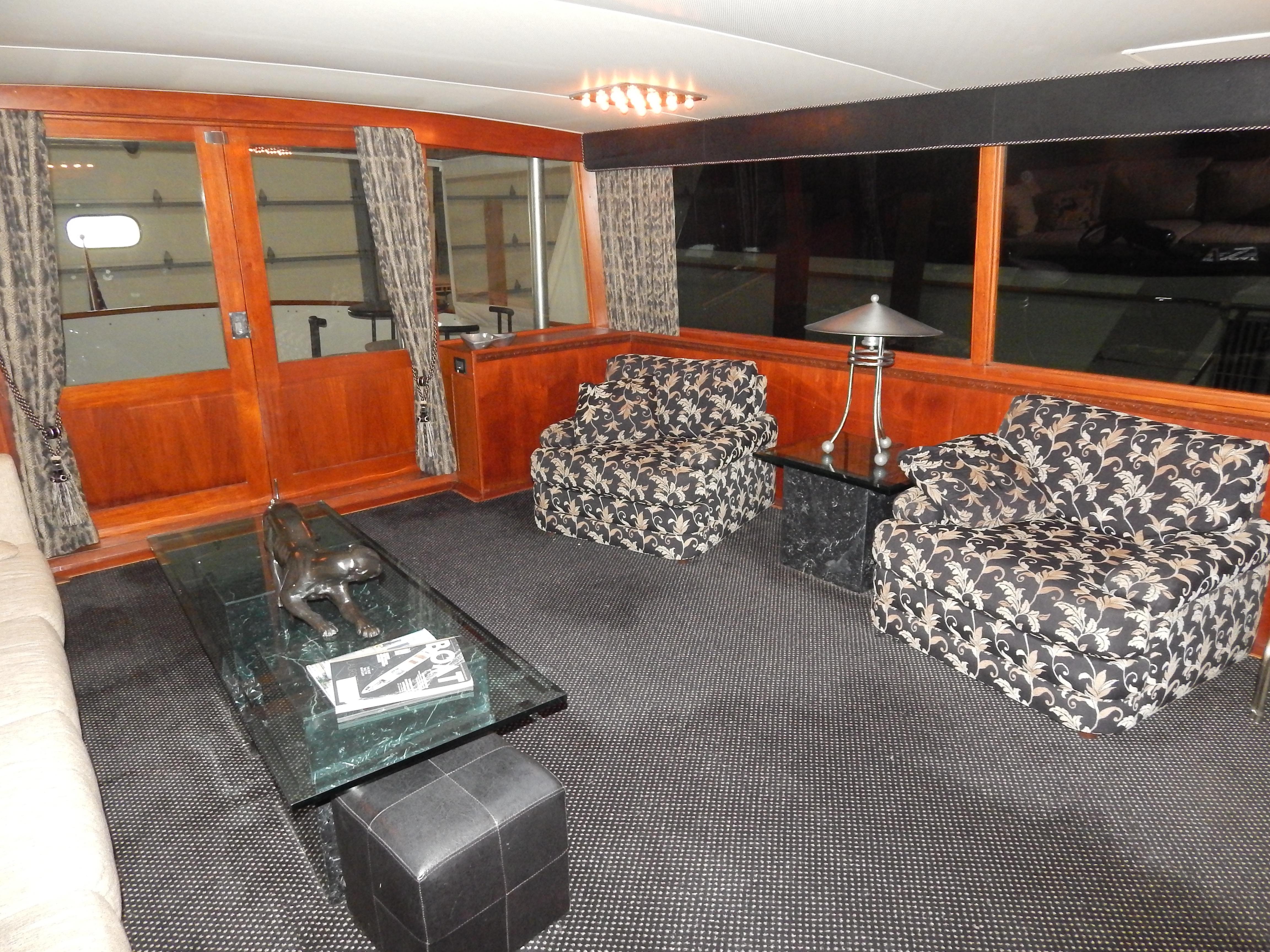 Interior of a 1974 Pacemaker Cockpit Motoryacht with floral chairs and wooden accents.