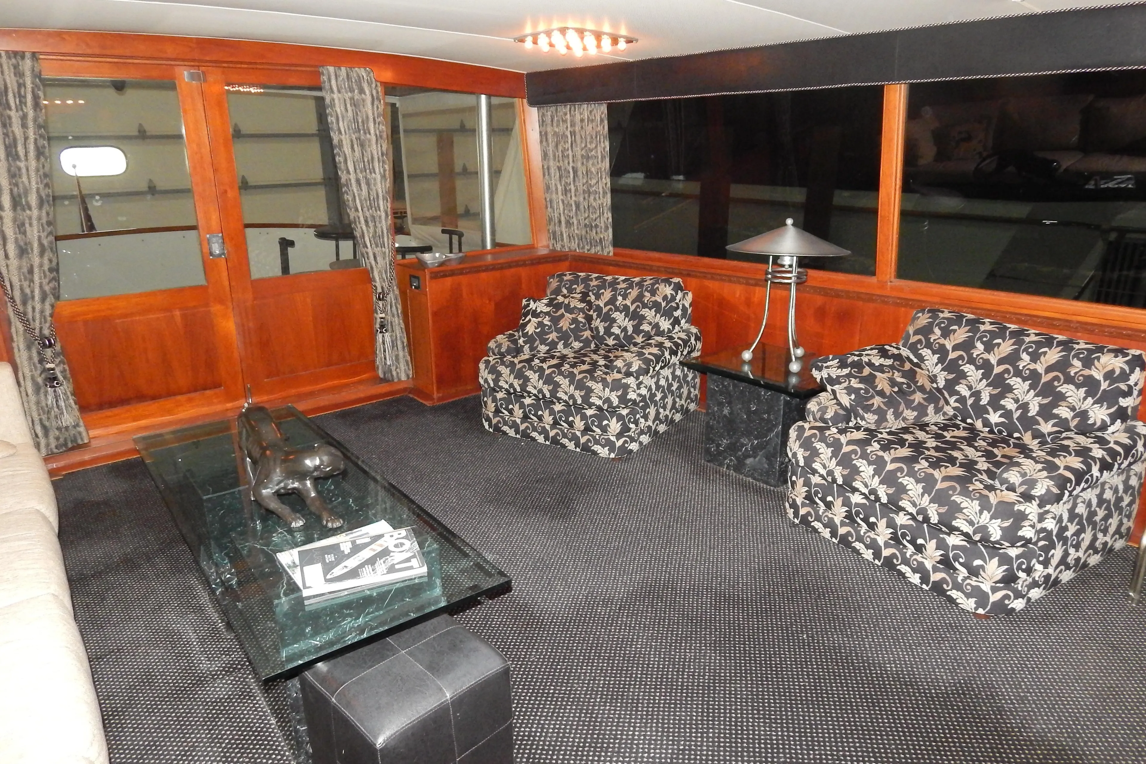 Interior of a 1974 Pacemaker Cockpit Motoryacht with floral chairs and wooden accents.