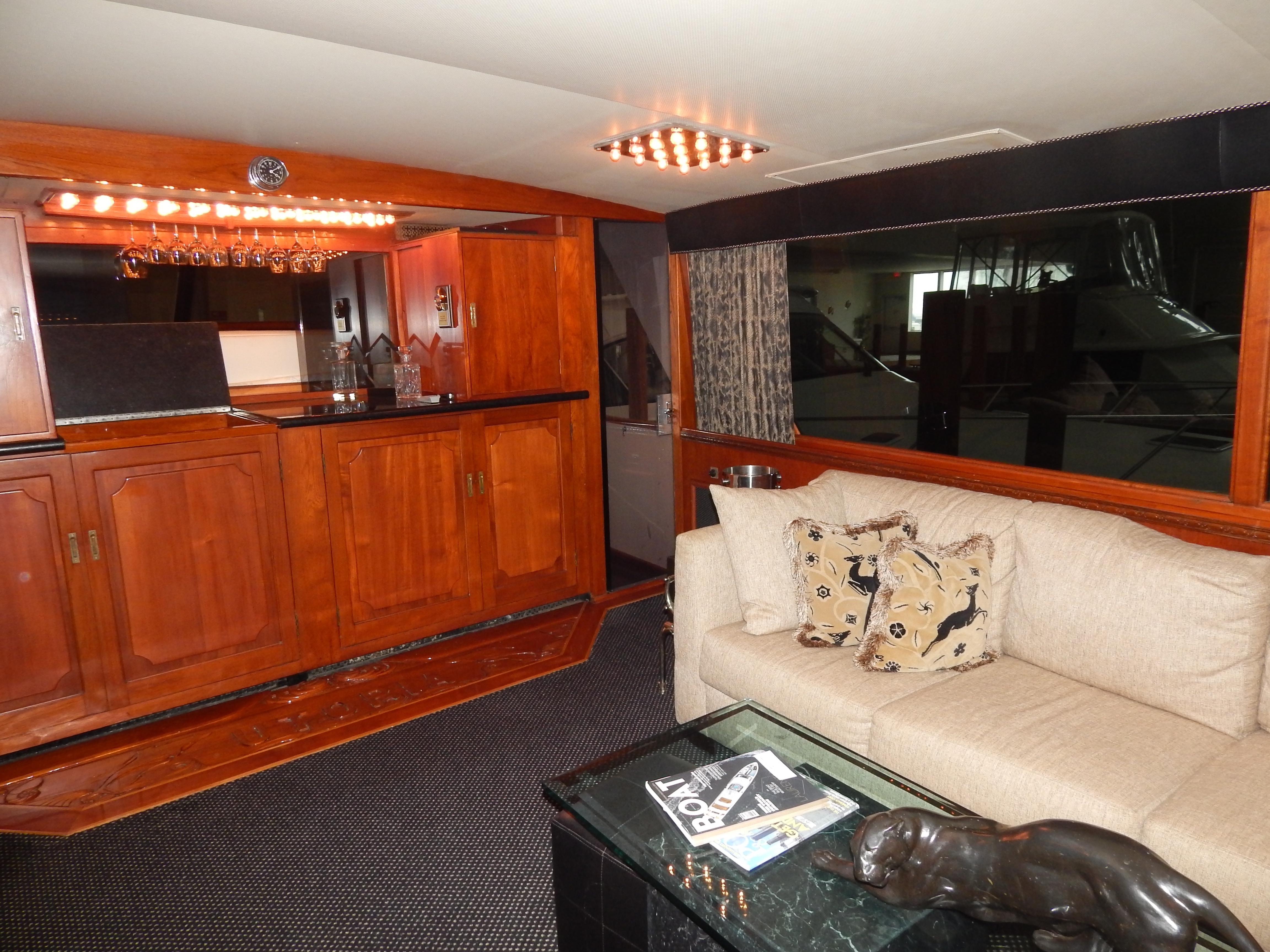 1974 Pacemaker Cockpit Motoryacht interior with wooden cabinetry, beige sofa, and decorative accents.