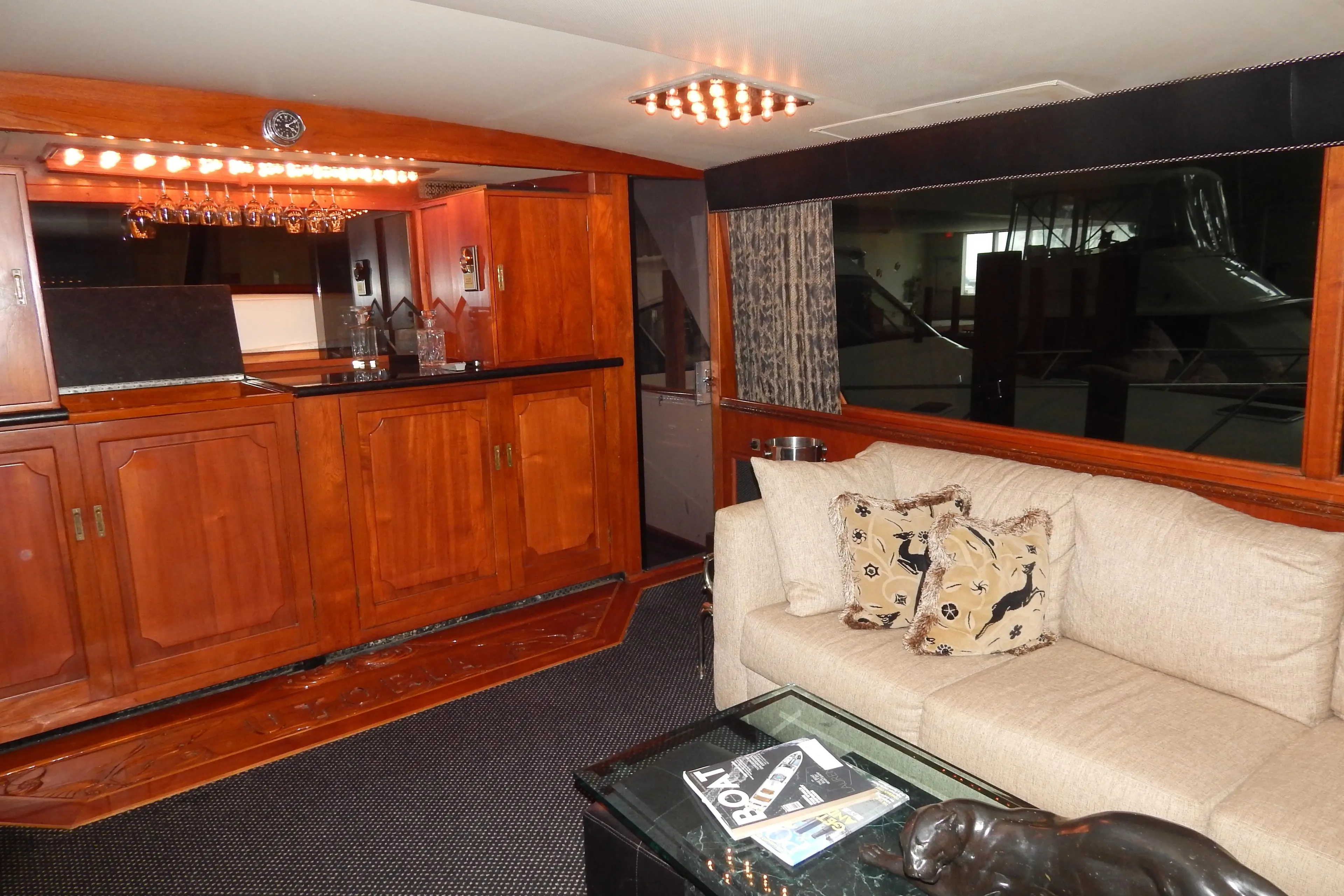 1974 Pacemaker Cockpit Motoryacht interior with wooden cabinetry, beige sofa, and decorative accents.