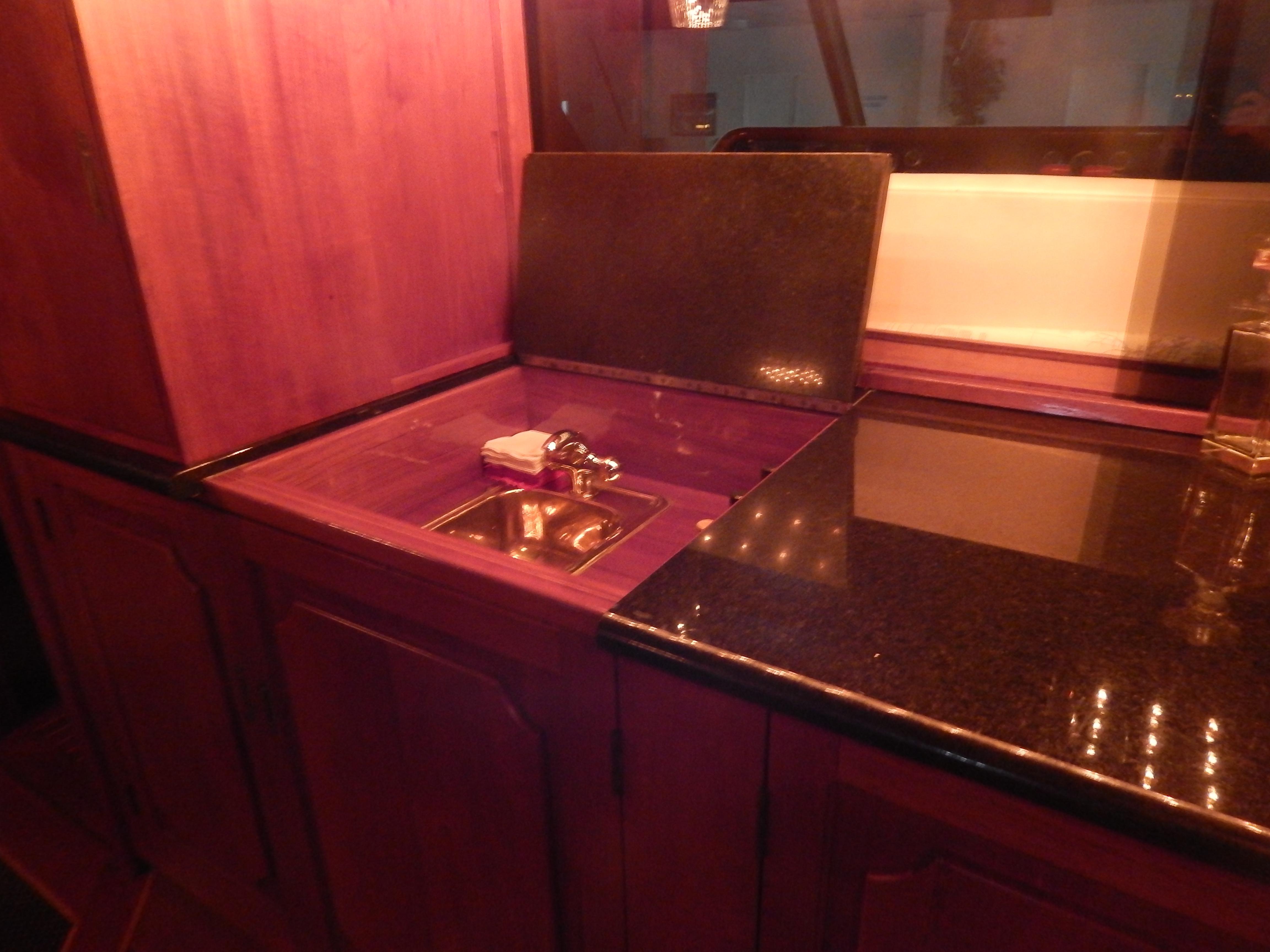 1974 Pacemaker Cockpit Motoryacht kitchen with wooden cabinetry and sleek countertop.