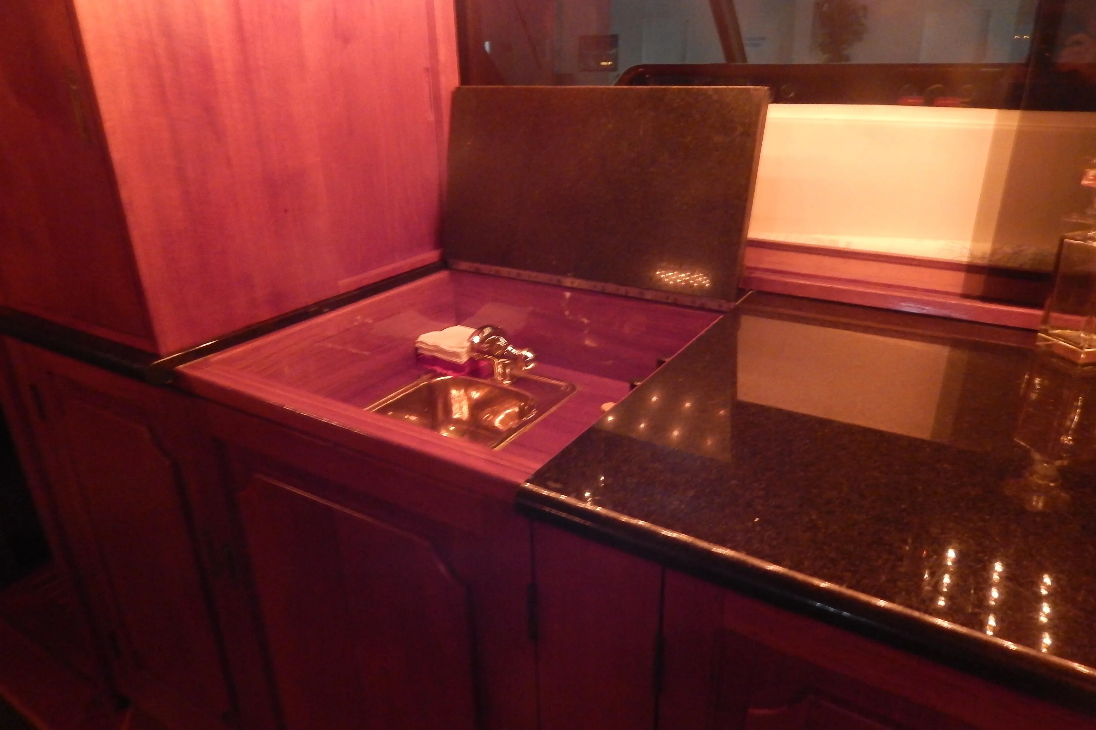 1974 Pacemaker Cockpit Motoryacht kitchen with wooden cabinetry and sleek countertop.