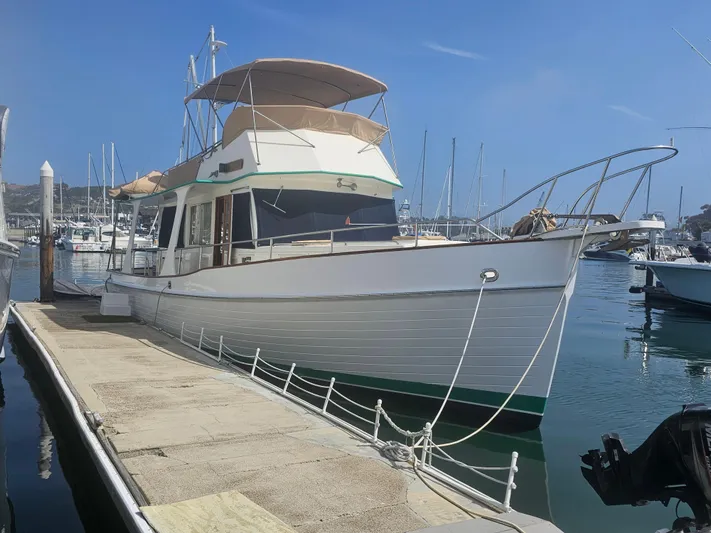 Marytime Yacht Photos Pics 1987 Grand Banks 42 Europa yacht docked at a marina under clear blue skies.
