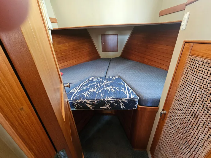 Marytime Yacht Photos Pics Cozy cabin interior of 1987 Grand Banks 42 Europa with wooden paneling and cushioned bedding.