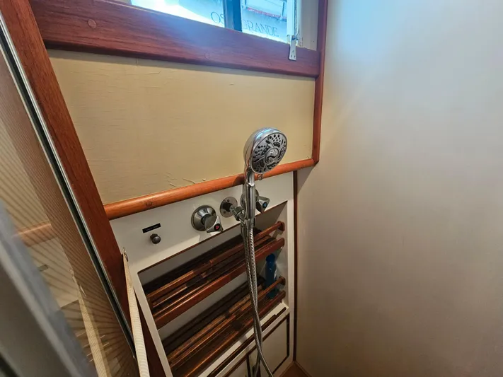 Marytime Yacht Photos Pics Shower area in 1987 Grand Banks 42 Europa yacht with wooden accents and handheld showerhead.