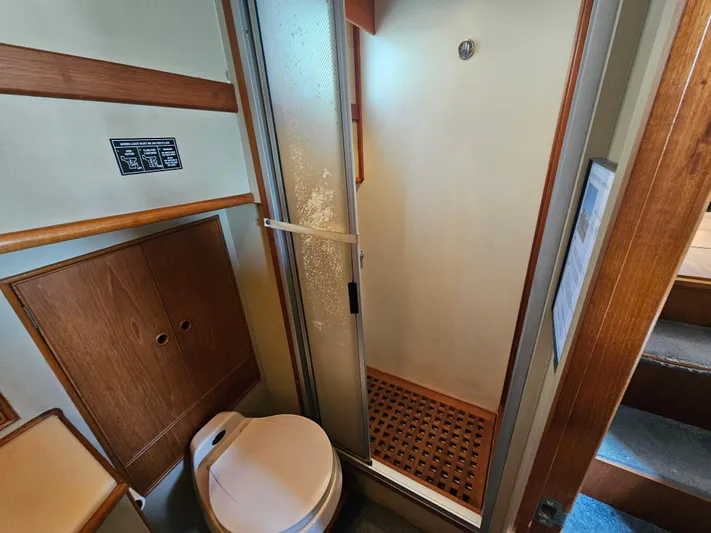 Marytime Yacht Photos Pics 1987 Grand Banks 42 Europa bathroom with shower, wooden cabinetry, and toilet.