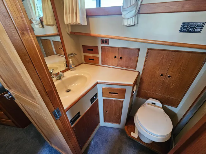 Marytime Yacht Photos Pics 1987 Grand Banks 42 Europa bathroom with wooden cabinetry, sink, and toilet.