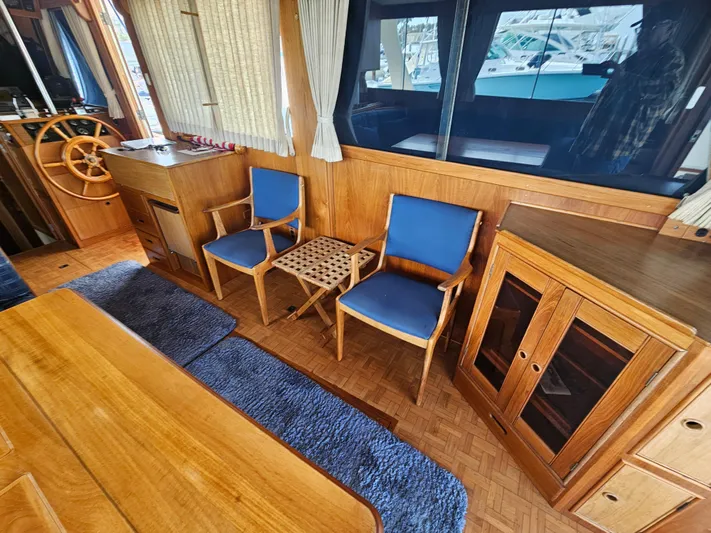 Marytime Yacht Photos Pics Interior of 1987 Grand Banks 42 Europa yacht with wooden furnishings and blue chairs.