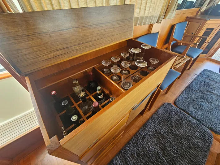Marytime Yacht Photos Pics Bar cabinet with glasses and bottles inside a 1987 Grand Banks 42 Europa yacht interior.