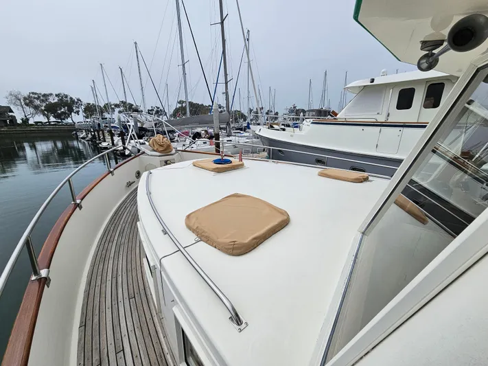 Marytime Yacht Photos Pics 1987 Grand Banks 42 Europa yacht docked in a marina, showcasing its spacious deck and classic design.
