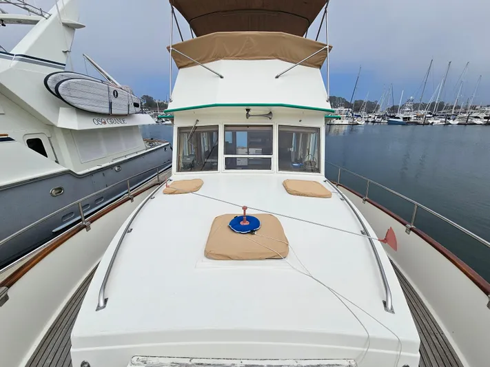 Marytime Yacht Photos Pics 1987 Grand Banks 42 Europa yacht docked in a marina, showcasing its spacious deck and classic design.