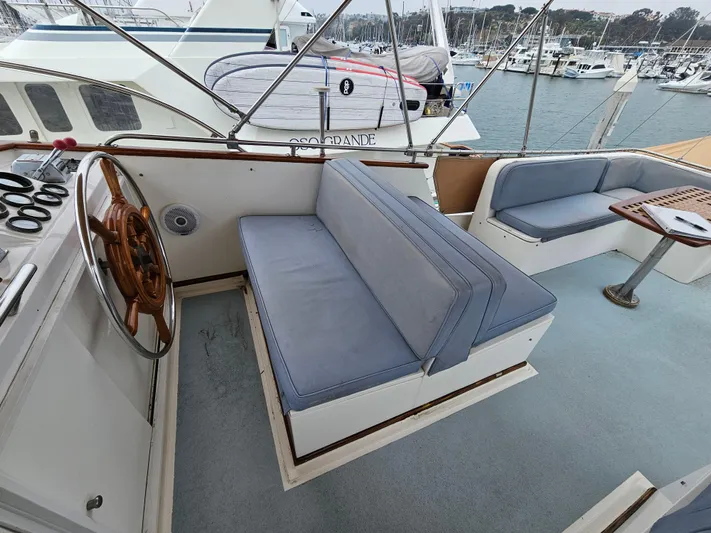 Marytime Yacht Photos Pics 1987 Grand Banks 42 Europa yacht interior with blue seating and wooden steering wheel.