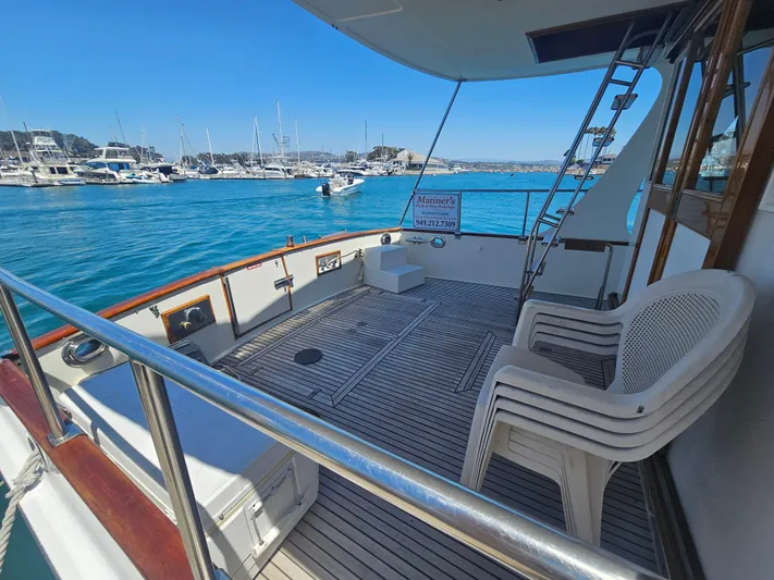 Marytime Yacht Photos Pics 1987 Grand Banks 42 Europa yacht deck with marina view, featuring seating and ladder.