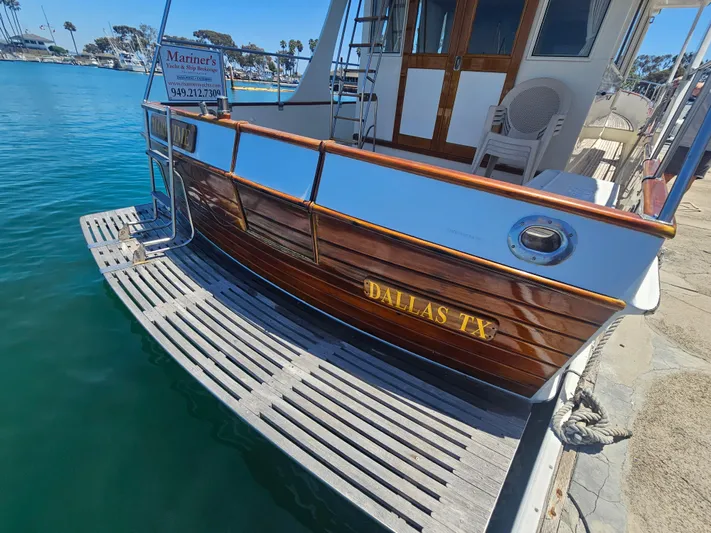 Marytime Yacht Photos Pics 1987 Grand Banks 42 Europa yacht docked, featuring polished wood and "Dallas TX" inscription.