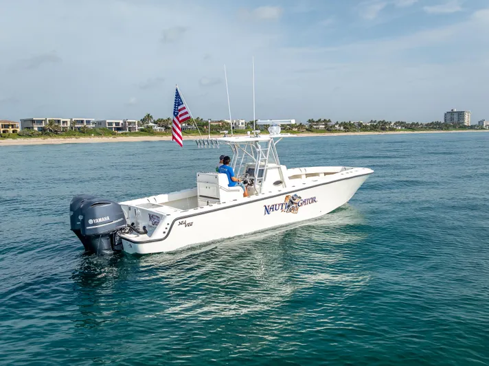  Yacht Photos Pics 2014 SeaVee 34 boat cruising on ocean, American flag, Yamaha engine, coastal background.
