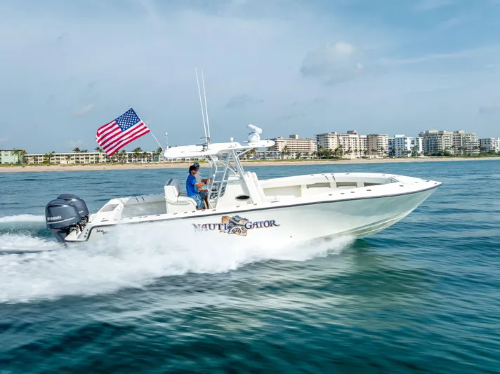  Yacht Photos Pics 2014 SeaVee 34 boat cruising on water with American flag, cityscape in background.