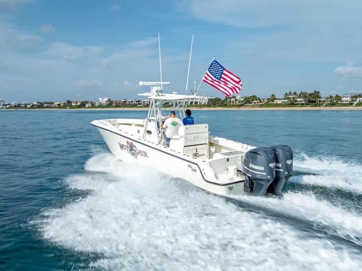  Yacht Photos Pics 2014 SeaVee 34 boat cruising with American flag, twin Yamaha engines, coastal background.