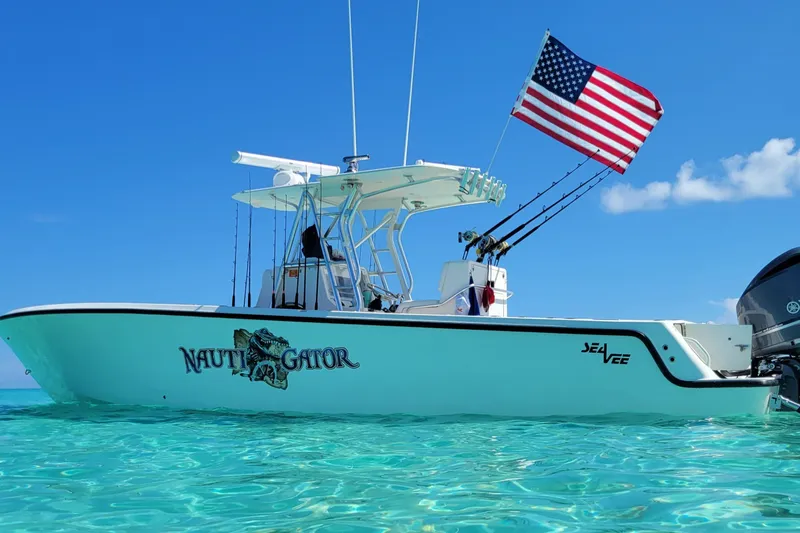  Yacht Photos Pics 2014 SeaVee 34 boat with American flag, named "Nauti Gator," on clear turquoise water.