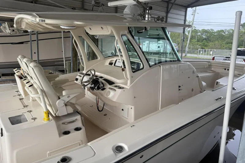 Yacht Photos Pics 2015 Grady-White Canyon 376 boat interior with helm and seating under a covered dock.