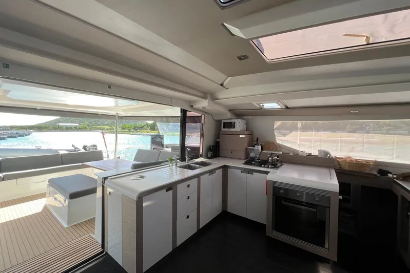 Portlish Yacht Photos Pics Modern kitchen interior of 2022 Fountaine Pajot Tanna 47 yacht with ocean view.