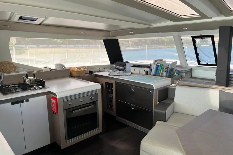 Portlish Yacht Photos Pics Interior of 2022 Fountaine Pajot Tanna 47 yacht, featuring modern kitchen and seating area.