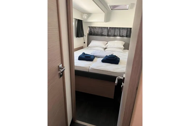 Portlish Yacht Photos Pics 2022 Fountaine Pajot Tanna 47 cabin interior with neatly arranged bed and towels.