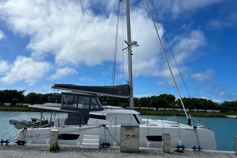 Portlish Yacht Photos Pics 2022 Fountaine Pajot Tanna 47 catamaran docked under a clear blue sky.