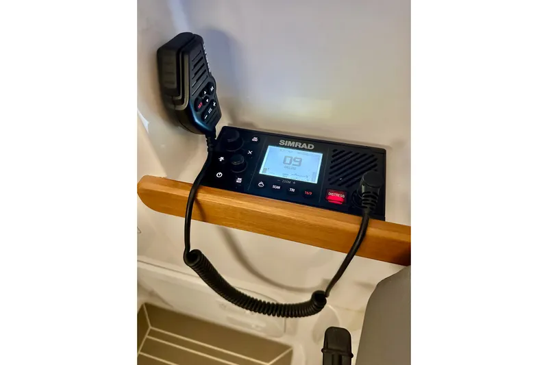 Delphin Yacht Photos Pics Simrad marine radio on 2023 Nimbus Weekender 9 boat, featuring a wooden handle.