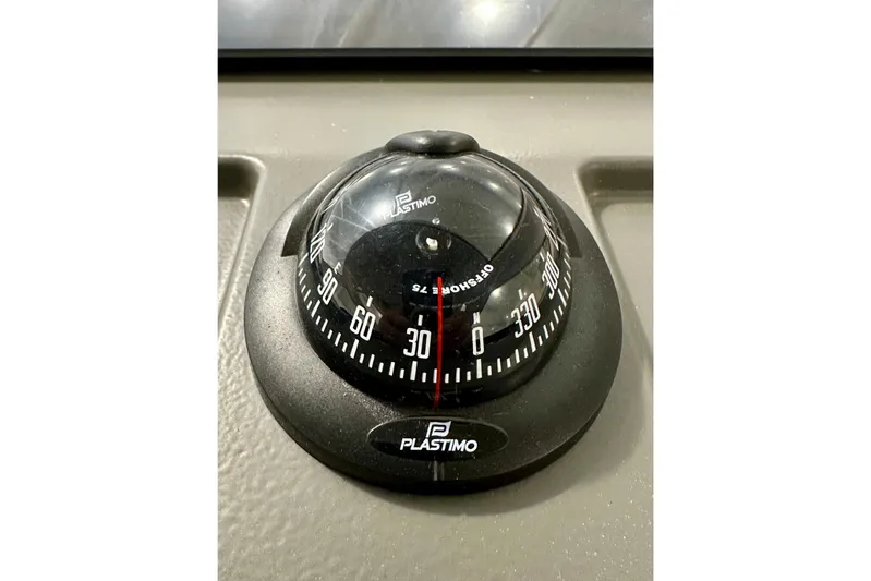 Delphin Yacht Photos Pics Compass on 2023 Nimbus Weekender 9 boat dashboard, featuring Plastimo branding.