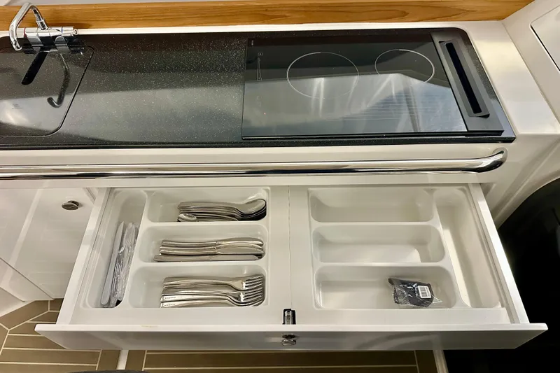 Delphin Yacht Photos Pics Modern kitchen in 2023 Nimbus Weekender 9 with stove and organized cutlery drawer.