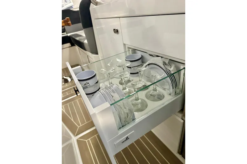 Delphin Yacht Photos Pics Drawer with glassware and dishes in 2023 Nimbus Weekender 9 boat interior.